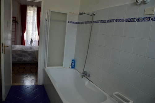 Bathroom in Rosa room at I colori della Sicilia B&B Caltagirone with white tiles, bathtub, and shower in Sicily accommodation