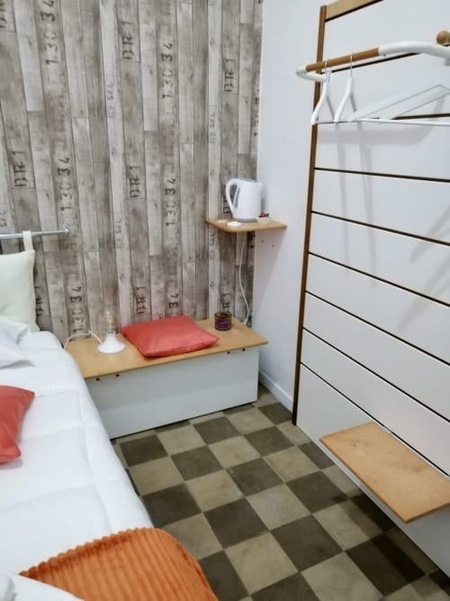 Modern bedroom at I colori della Sicilia in Caltagirone with wood-patterned wallpaper, white furniture, coral accents, and