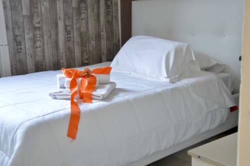 White bedding with orange ribbon at I colori della Sicilia B&B in Caltagirone, Sicily