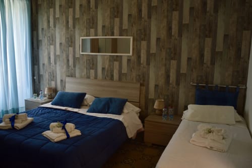 Camera doppia nella stanza Lavanda presso I colori della Sicilia B&B a Caltagirone con parete in legno, biancheria blu e punto di riferimento