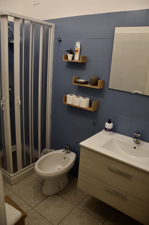 Modern bathroom in Lavanda room at I colori della Sicilia B&B, Caltagirone, with blue tiled walls, white sink, bidet, toilet,