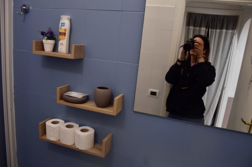 Bathroom shelves with toiletries and toilet paper rolls at I colori della Sicilia B&B in Caltagirone