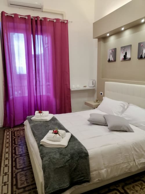 Camera Orchidea presso I colori della Sicilia B&B a Caltagirone con tende rosa e biancheria bianca