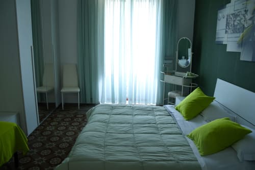 Bright bedroom at I colori della Sicilia in Caltagirone with green accents, modern furnishings, and landmark views through