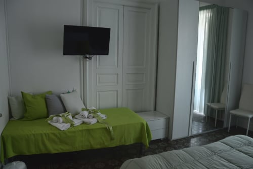 Bright modern bedroom at I colori della Sicilia in Caltagirone with lime green bedding, flat-screen TV, and landmark views