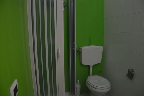 Bathroom in Giglio room at I colori della Sicilia, Caltagirone - white toilet and sink against bright green wall