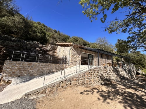Stone cottage with ramp entrance at Domaine du Chambonnet, Chalencon, surrounded by trees with mountain views