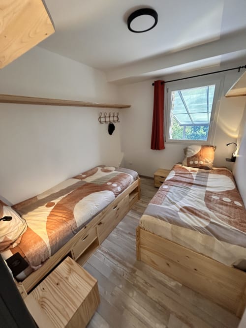 Bright twin bedroom in Gîte Les Oliviers d'Ardèche cottage, Chalencon, with natural light and mountain views