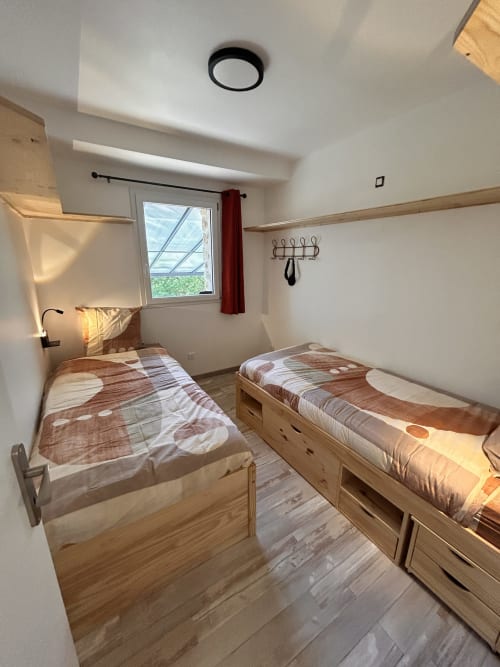 Twin bedroom with wooden beds in Gîte Les Oliviers d'Ardèche cottage, Chalencon