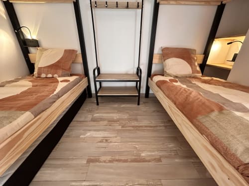 Twin bedroom in Gîte Les Oliviers d'Ardèche cottage with wooden beds and mountain views