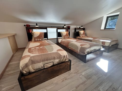 Attic bedroom at Domaine du Chambonnet with three beds, brown bedding, and mountain views through skylights in Chalencon,
