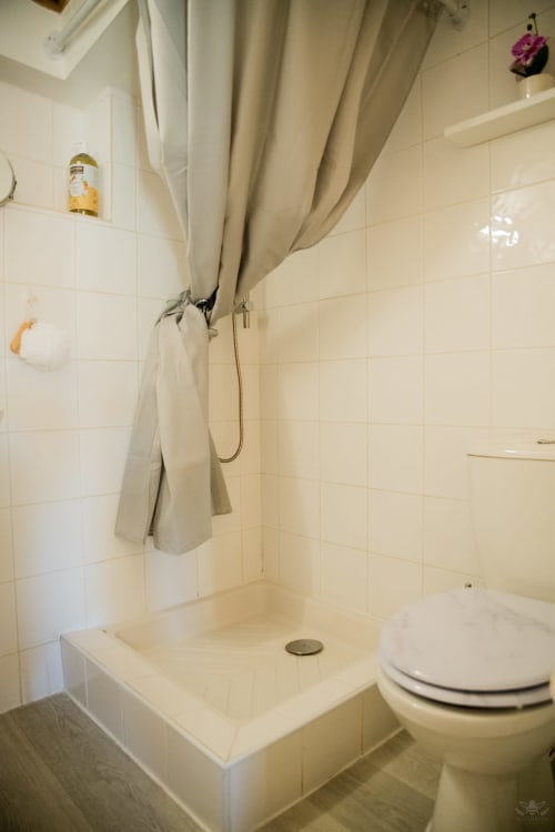 Salle de bain épurée avec douche, toilettes et carrelage neutre à la maison d'hôtes Mi Casa Es Su Casa, Carcassonne