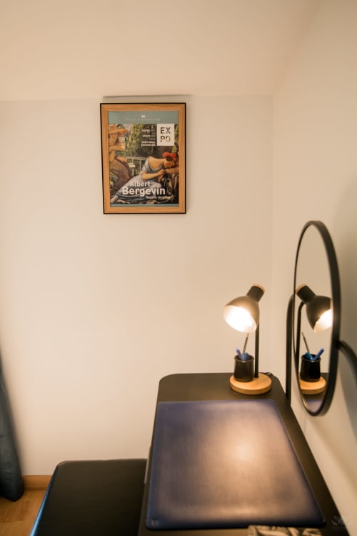 Lampe de bureau moderne et miroir dans la chambre de la maison d'hôtes Mi Casa Es Su Casa, Carcassonne, avec affiche d'Albert Bergevin au mur