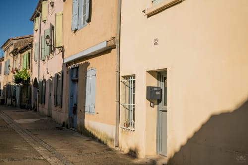 Charmante maison jaune aux volets bleus et porte verte dans une rue tranquille de Carcassonne, France
