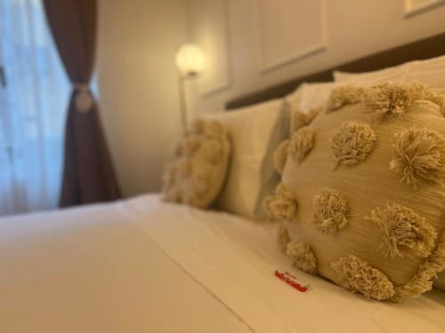 Camera elegante presso A Casa di Imma Milano con cuscini dorati decorativi e illuminazione ambientale
