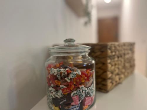Vaso decorativo in vetro con frammenti di tessuti colorati sulla mensola dell'appartamento A Casa di Imma a Milano