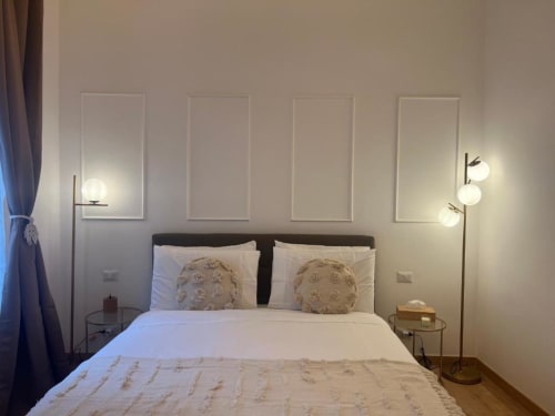 Camera da letto moderna dell'appartamento A Casa di Imma Milano con letto matrimoniale, cuscini decorativi, applique murali e arredamento contemporaneo