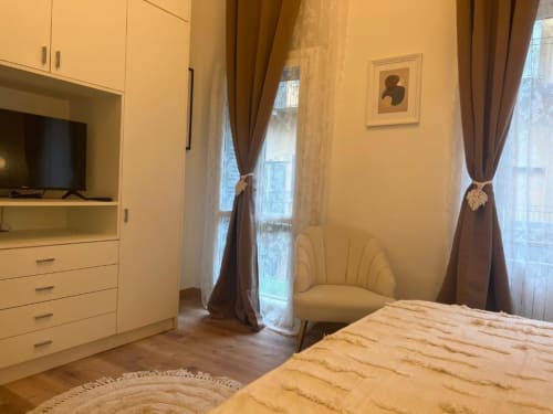 Camera moderna ad A Casa di Imma Milano con letto arredato, guardaroba integrato, poltrona e balcone con vista città