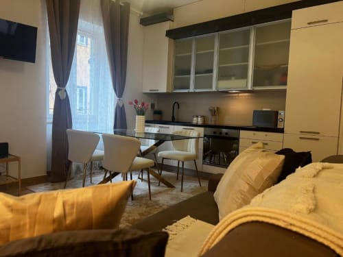 Monolocale moderno a Milano con divano giallo, cucina e zona pranzo vicino a Bocconi e Duomo