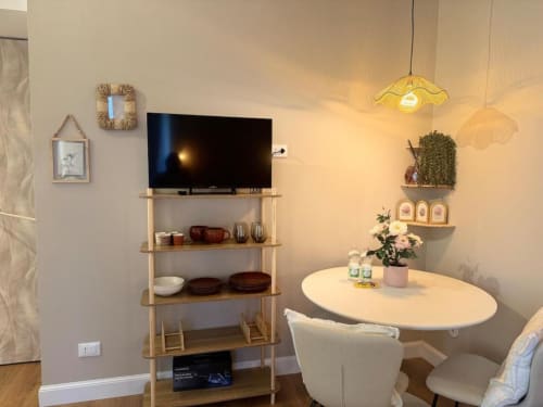 Moderna zona living con TV, tavolo da pranzo, scaffalature e piante vicino al Duomo di Milano