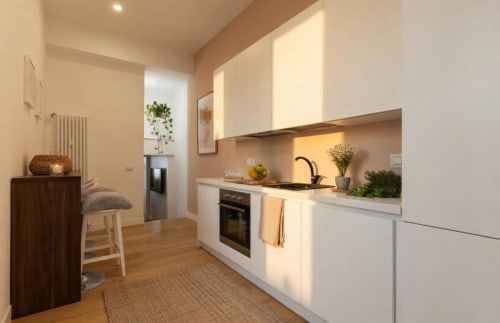 Cucina moderna nell'appartamento A Casa di Imma a Milano, con mobili bianchi, forno incorporato e zona bar
