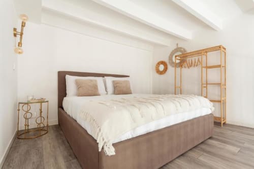 Ampia camera da letto in A Casa di Imma Milano con letto marrone, dettagli dorati e pavimento in legno