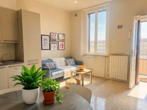 Luminoso appartamento a Milano vicino a Bocconi con cucina a vista, comodo divano, piante e vista dal balcone