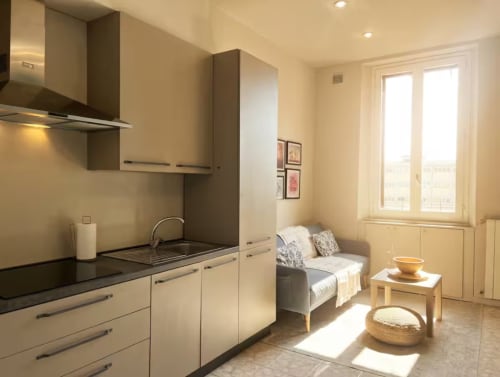 Luminoso monolocale a Milano con cucina moderna, letto e ampia luminosità naturale dalle vetrate vicino a Bocconi