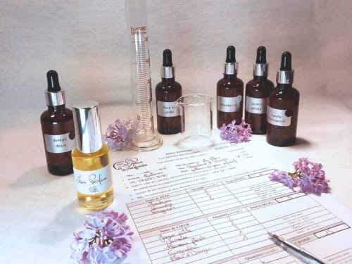 Flacons de parfum artisanal et nuancier de composition avec fleurs violettes à la Maison D'hôtes Cœur D'hérault à Péret