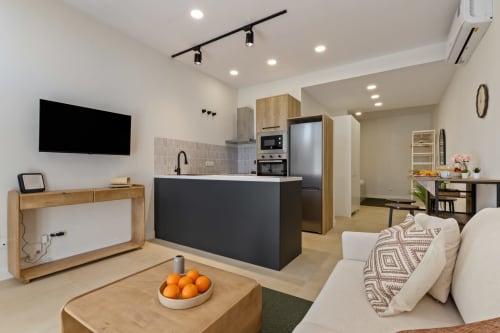 Modern Ayma Suite apartment in Alhaurín de la Torre featuring open-plan living with kitchen, dining area, lounge with TV and