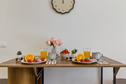 Elegantly set dining table at Ayma Suite with fresh fruit, flowers, and juice glasses at Alhaurín de la Torre property.
