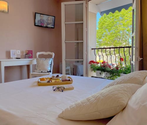 Chambre twin à l'Hôtel le Vauban de Carentan avec balcon donnant sur des arbres verts et des fleurs