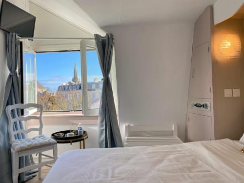 Chambre twin à l'Hôtel le Vauban de Carentan avec vue sur le clocher, lit blanc et équipements modernes