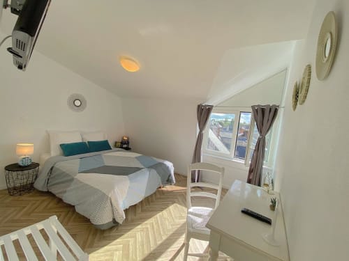 Chambre twin lumineuse à l'Hôtel le Vauban de Carentan, avec plafond mansardé, parquet, bureau et ventilateurs de plafond