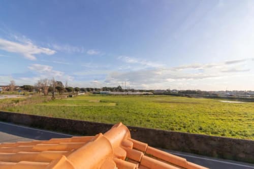 Albergue Sleep & Go em Esposende, Portugal com telhado de telhas laranja vista para campos verdes e paisagem rural