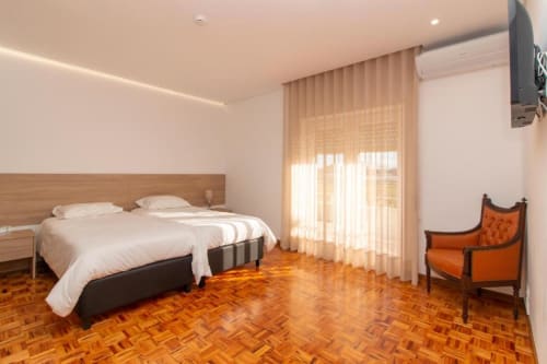 Espaçoso quarto twin standard no Sleep & Go hostel em Esposende com piso de madeira, comodidades modernas e luz natural