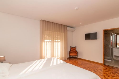 Quarto Twin luminoso no Sleep & Go hostel em Esposende com piso em madeira, camas brancas e comodidades modernas