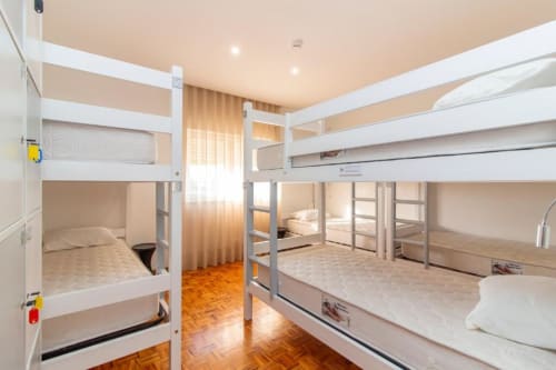 Beliches do hostel Sleep & Go em dormitório misto em Esposende com estruturas brancas, piso de madeira e instalações compartilhadas