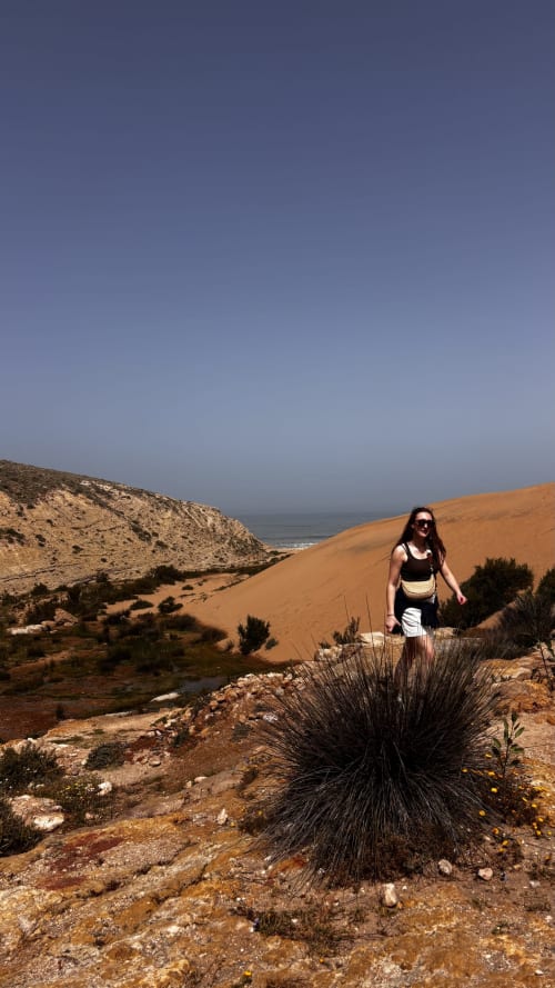 Femme en randonnée sur les dunes de sable côtières près d'Essaouira avec vue sur l'océan, Maison la Chèvre