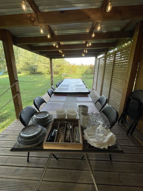 Pergola de salle à manger en plein air aux Jardins Du Soleil, Avignon avec tables longues, couverts et vues sur le jardin
