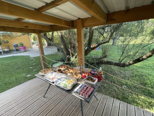 Petit-déjeuner en buffet en plein air sous la pergola des Jardins Du Soleil, chambre d'hôtes à Avignon