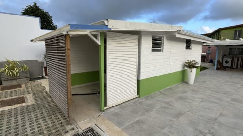 Bungalow contemporain aux façades blanc et vert à la Résidence B&L Lagon, Sainte-Luce, avec entrée à jalousies et terrasse