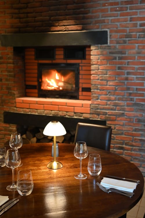 Table élégante à Au Bon Gîte à Senones avec cheminée et verres de vin, ambiance chaleureuse et accueillante