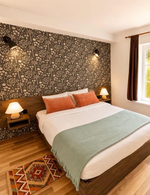 Chambre moderne au Gîte Au Bon Gîte à Senones avec tête de lit motifs, literie blanche, oreillers orange et parquet.