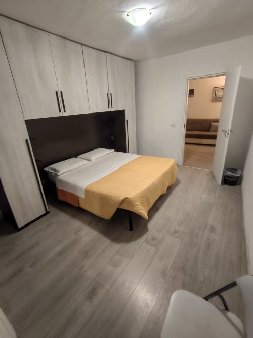 Modern bedroom at Casa di Alfredo in Siena with queen bed, built-in wardrobe, and living area access