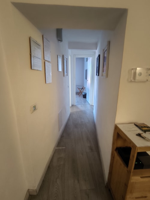 Narrow hallway in Casa di Alfardo apartment, Siena with wood flooring and white walls