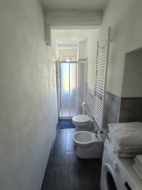 Modern bathroom in Casa di Alfredo apartment, Siena, with toilet, bidet, shower enclosure, and heated towel rack