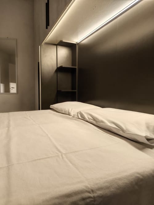 Modern bedroom at Casa di Alfredo in Siena with bed, pillow, black shelving unit, ambient ceiling lighting, and mirror