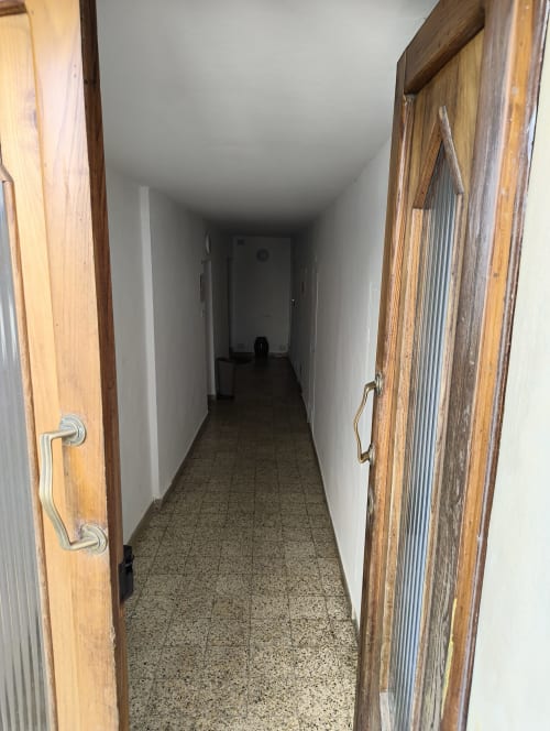 Long narrow hallway with wooden doors at Casa di Alfredo apartment in Siena, Italy