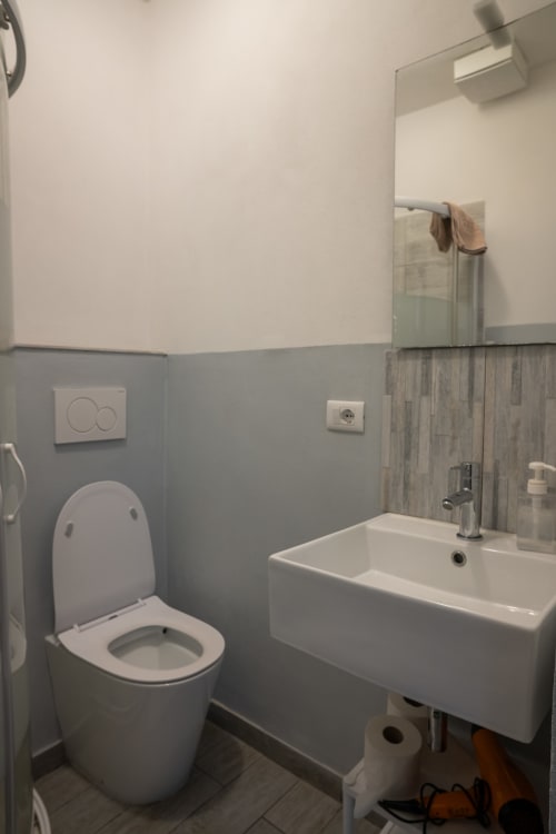 Moderno bagno condiviso presso Casa di Alfredo B&B a Siena con wc, lavabo, specchio e pareti piastrellate